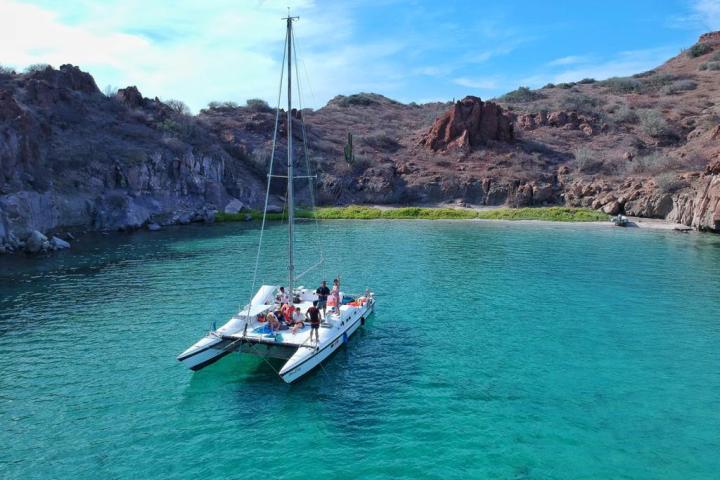 a small boat in a body of water with a mountain in the background